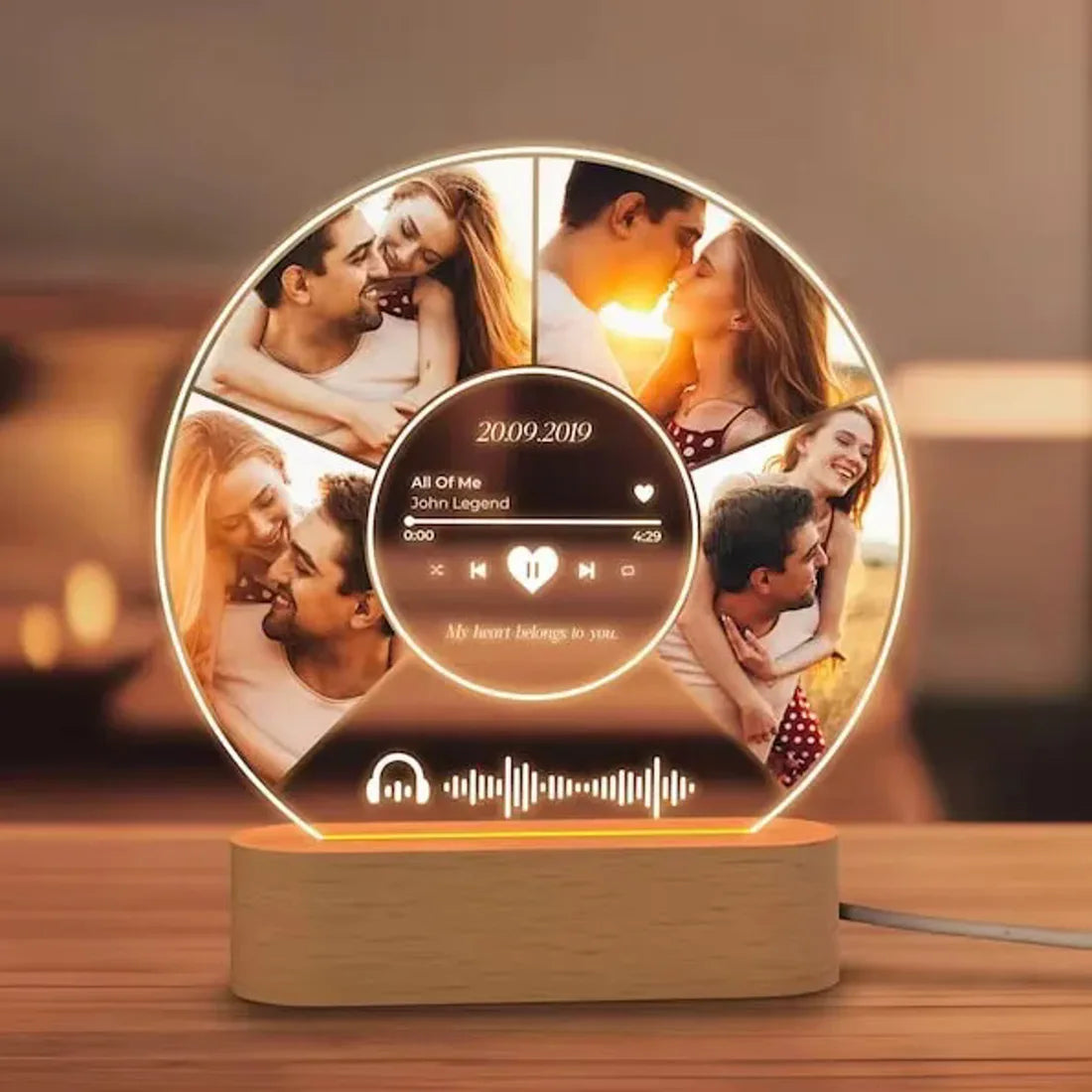 Round plaque with several photos and a song code, lit up on a table.